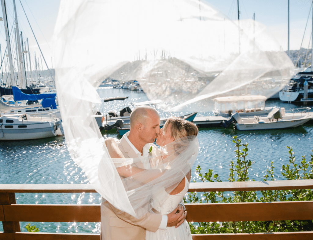 wedding couple with bride's train caught in the wind