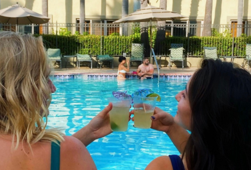 Yellow cocktail drinks holding by two person