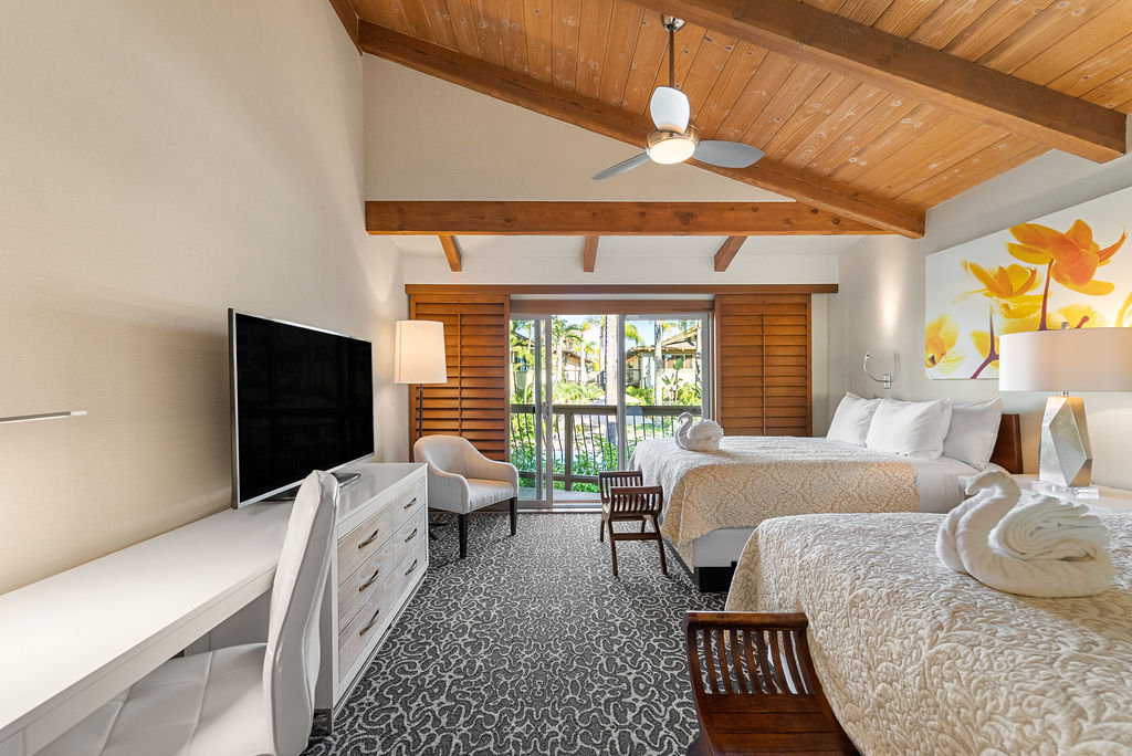 Two queen bedroom with desk and TV on dresser view of patio
