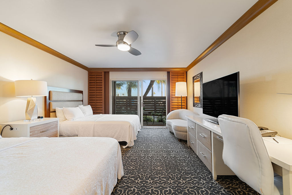 Two queen guest bedroom with TV and dresser and desk