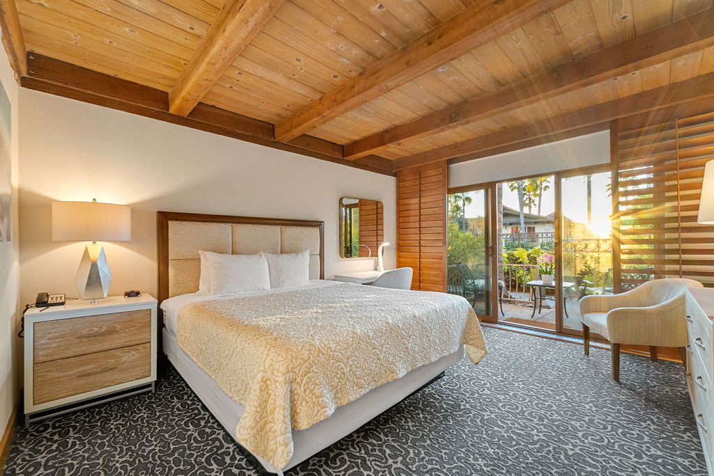 One King Bedroom guestroom with desk, and patio view