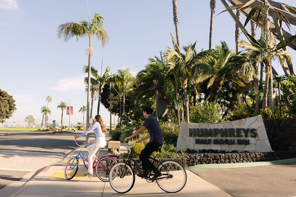 Guests riding bikes in front of entry sign