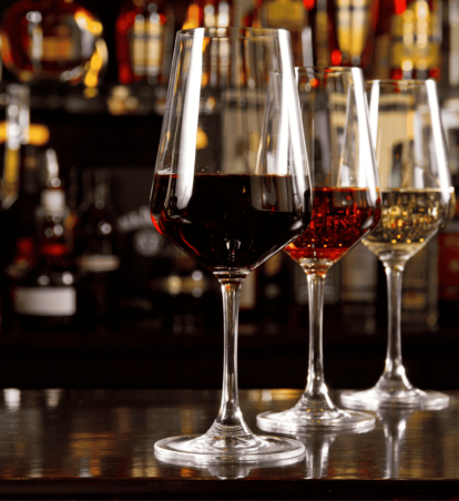 three glasses of different colored wine