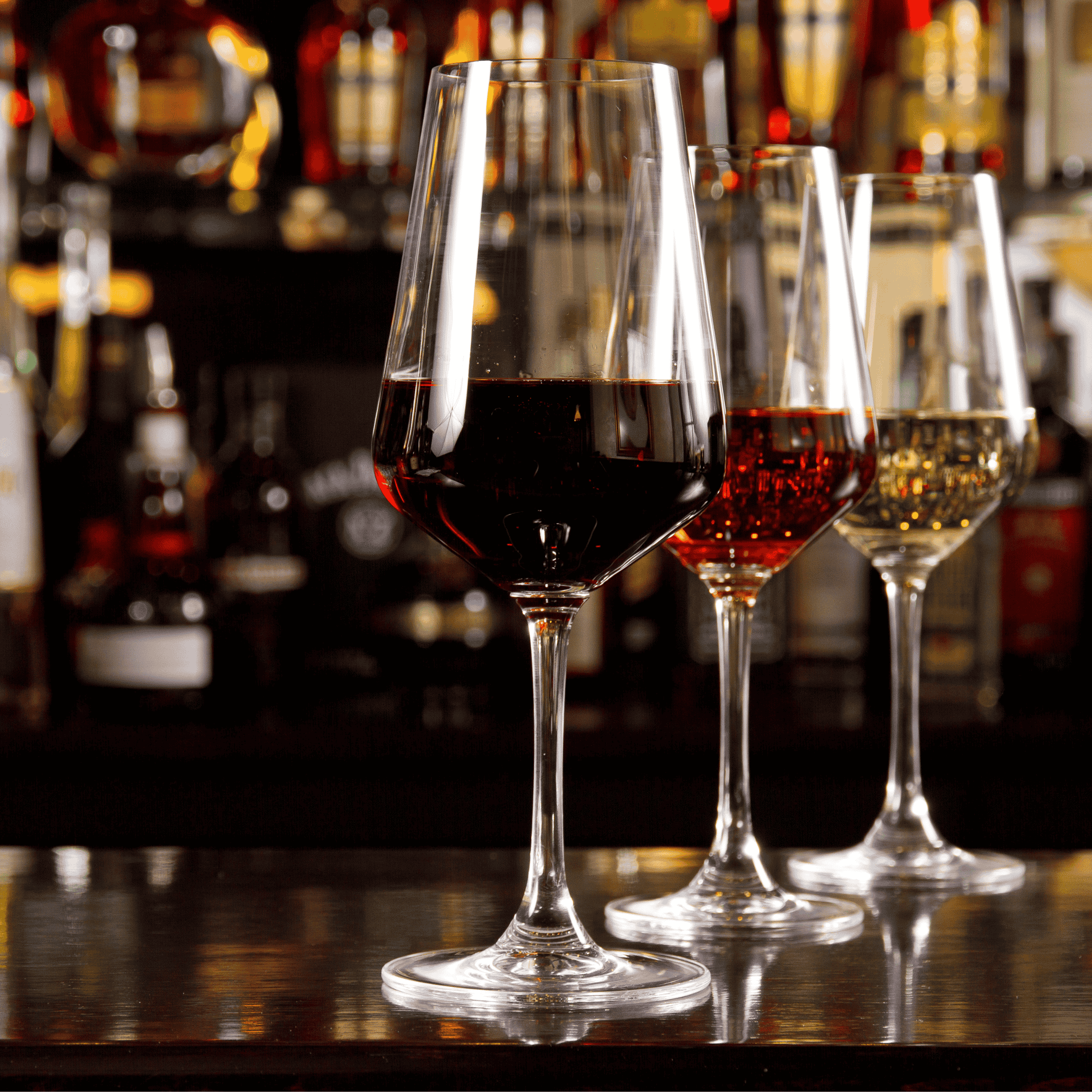 three glasses of different colored wine