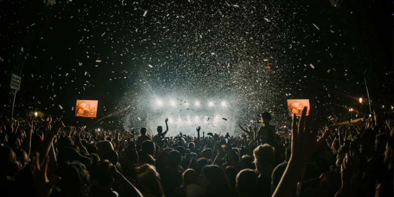 Nighttime festival with people cheering as confetti rains down