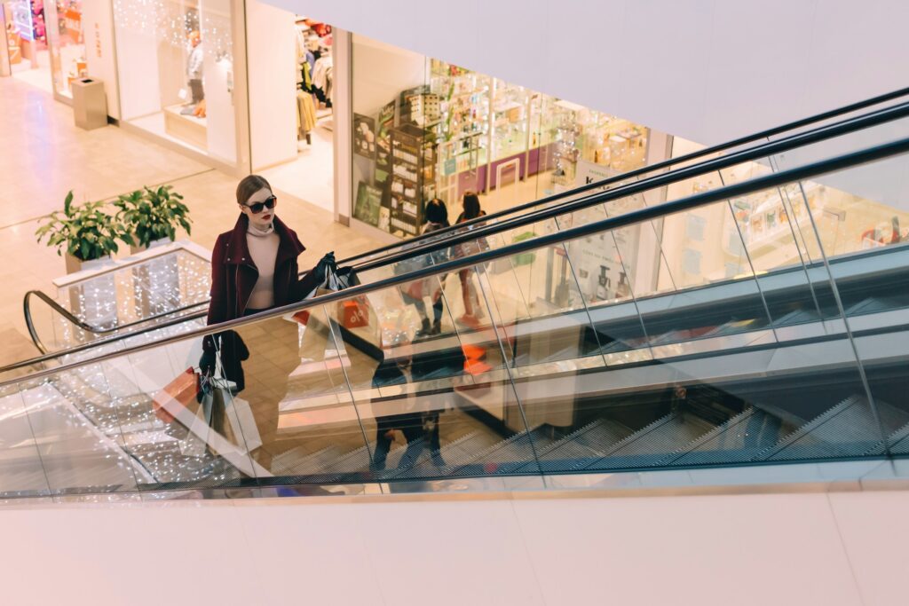a woman with shopping bags on an escalator
