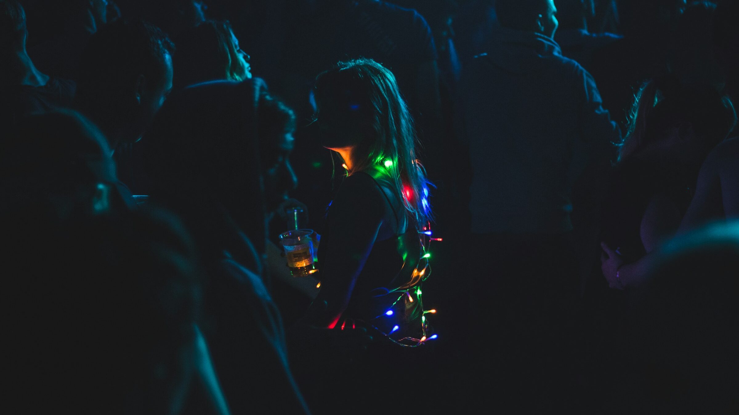 a woman with christmas lights in a dark crowd