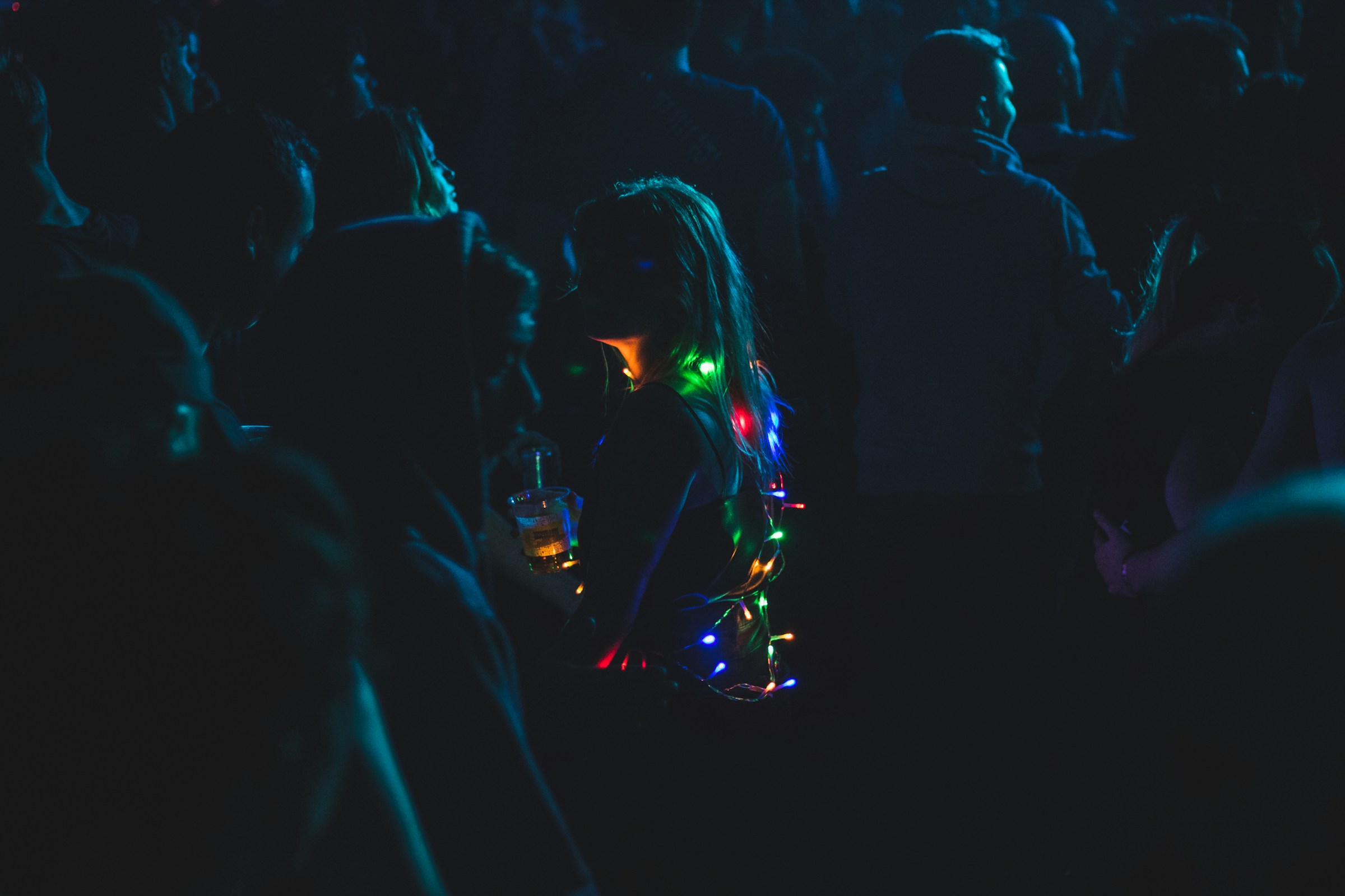 a woman with christmas lights in a dark crowd