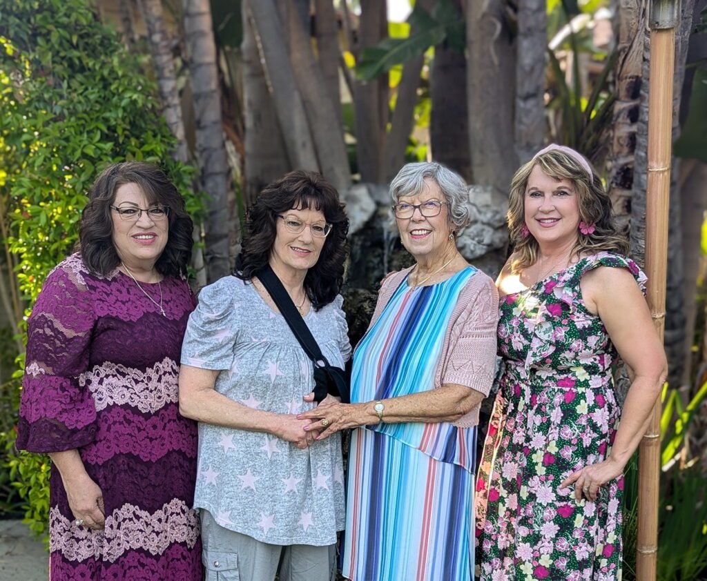 group of women standing in front of palm trees