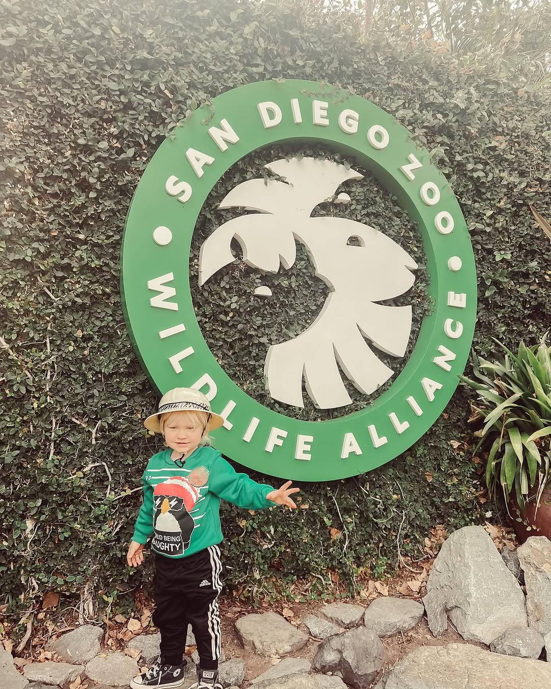 kid standing in front of san diego zoo sign