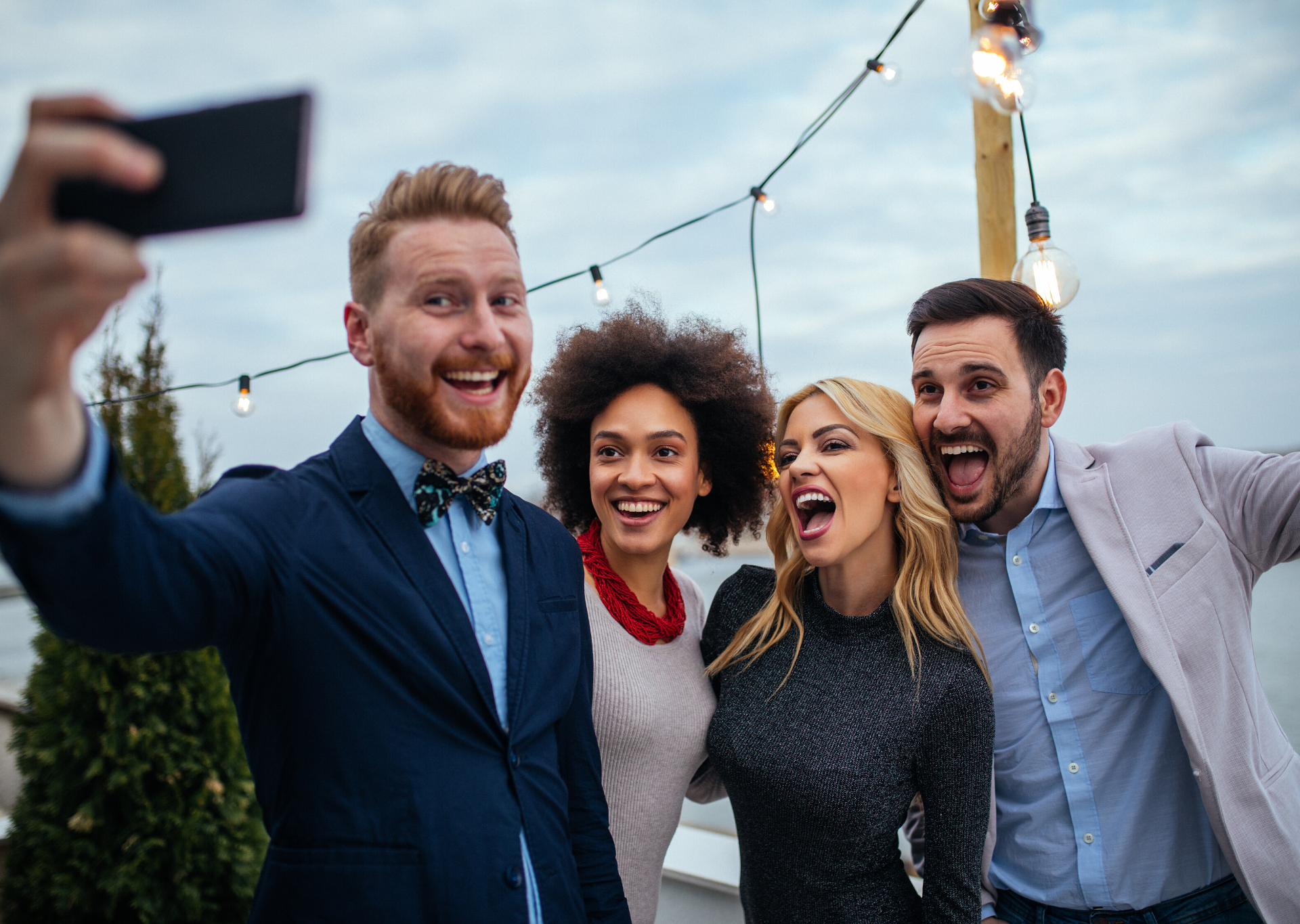Group of coworkers smiling and taking a selfie